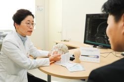진료실에서 군발두통 환자에게 설명 중인 조수진 교수
