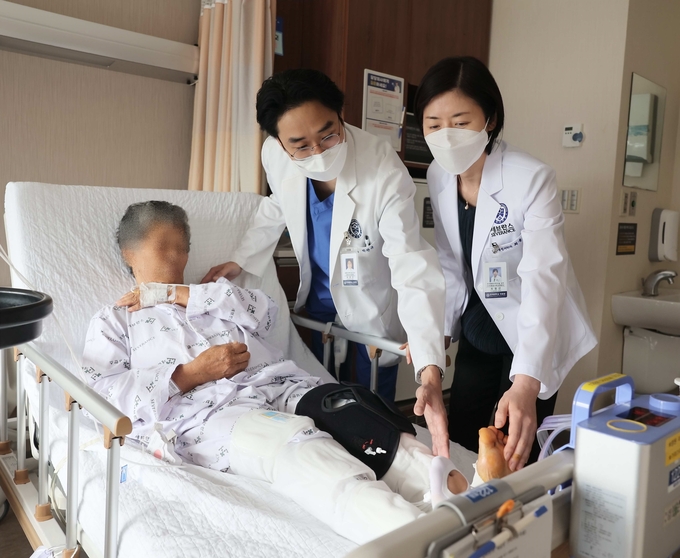 박관규(가운데), 최용선 교수(오른쪽)가 인공관절 수술 환자를 살피고 있다.